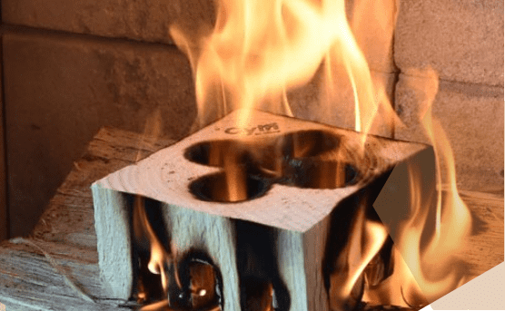 Cylfi houtblok brandend in open haard Brandend Cylfi houtblok met karakteristieke uitgefreesde openingen, opgesteld in een open haard met hoge vlammen.
